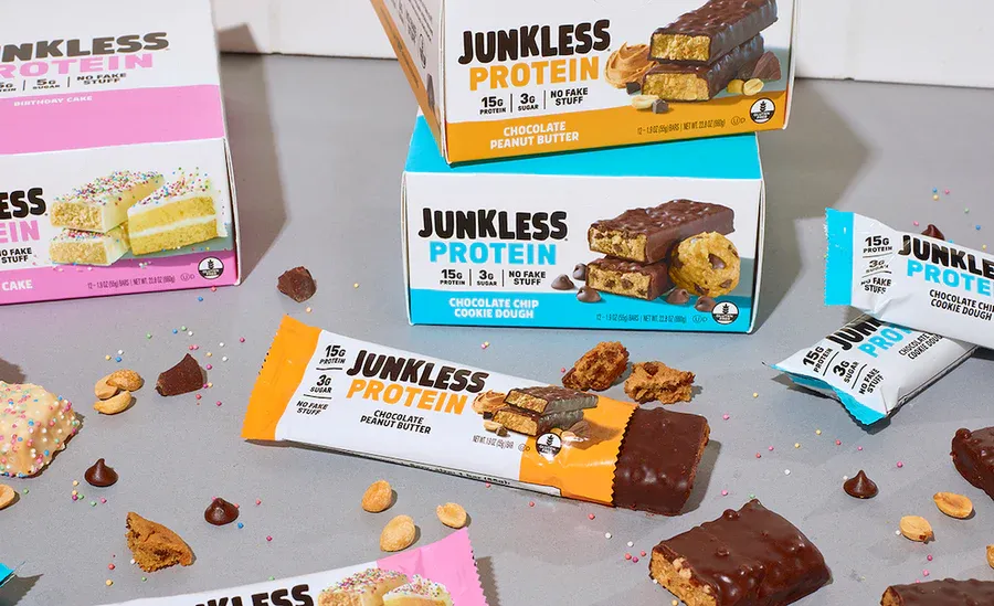JUNKLESS protein bar cartons stacked on a warehouse shelf